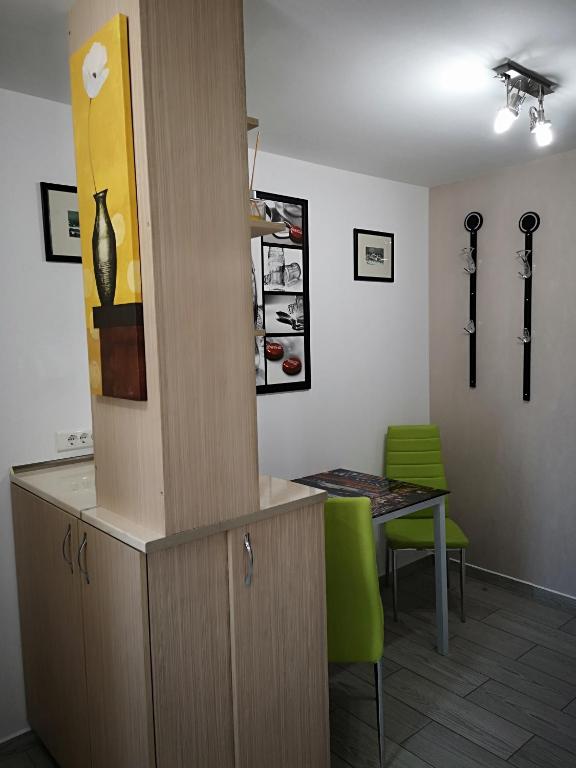 a room with a table and a cabinet with a green chair at apartament parc cetate in Alba Iulia
