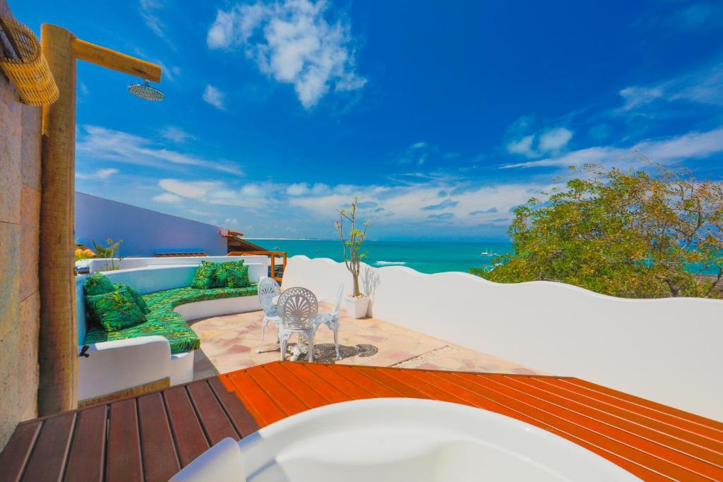 una terraza al aire libre con vistas al océano en Encanto das Flores, en Pipa