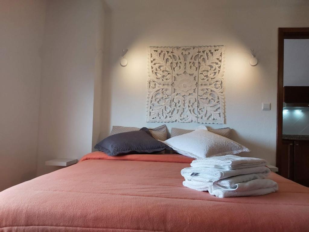 a bedroom with a red bed with towels on it at Tabua Village Adventure Room #6 with Ocean View in Ribeira Brava