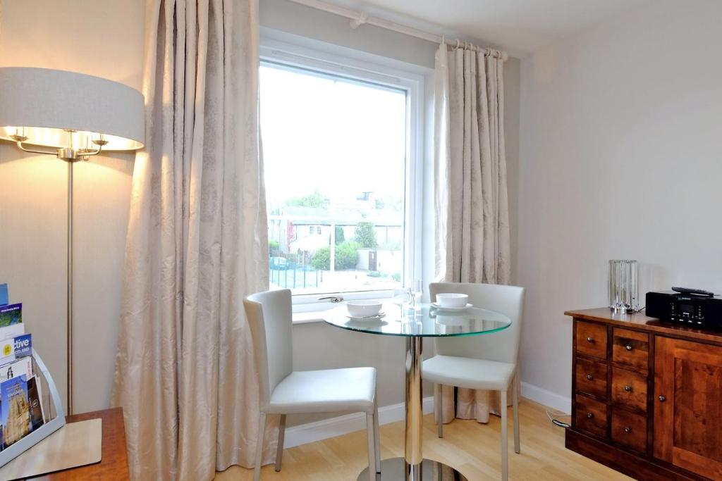 uma sala de jantar com uma mesa e cadeiras e uma janela em Fonthill Apartment - central, free parking off street em Aberdeen