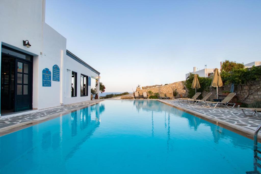 uma piscina com água azul em frente a um edifício em Sea View Studios em Amoopi