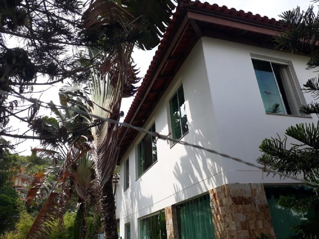 uma casa branca com uma palmeira em frente em Casa da Praia em Itajaí