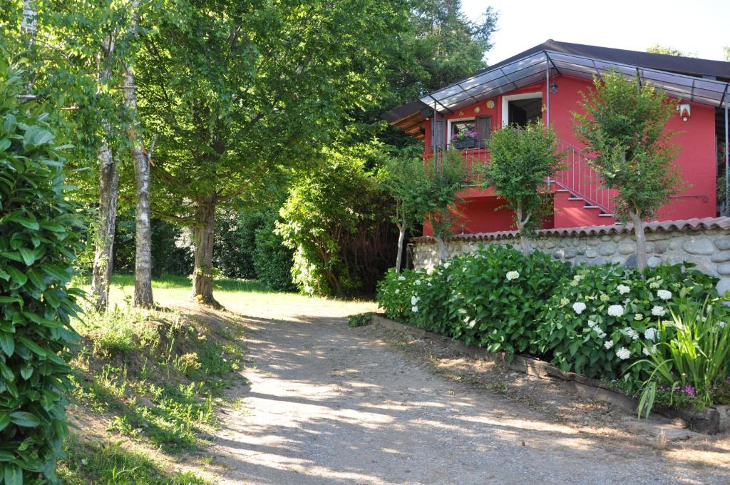 una casa roja con un camino que conduce a ella en la casa rossa nel bosco, en Cantù