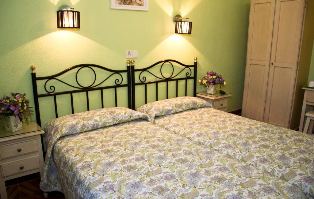 a bed in a bedroom with green walls and lights at Hostal Los Alpes in Madrid