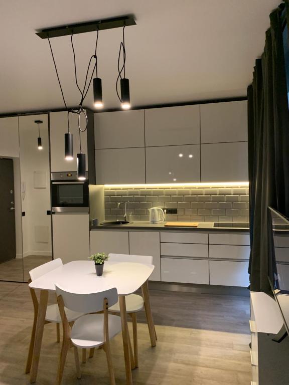 a kitchen with a white table and chairs at Near Ozas Studio in Vilnius