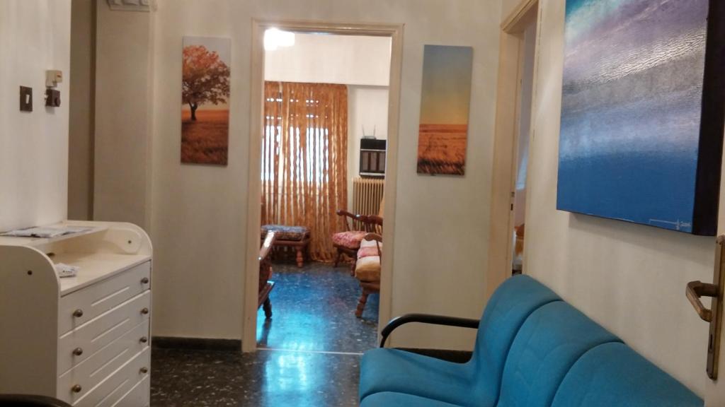 a living room with a blue couch and a tv at Entire House with garage, yard at Amfiali close to Piraeus Port in Piraeus