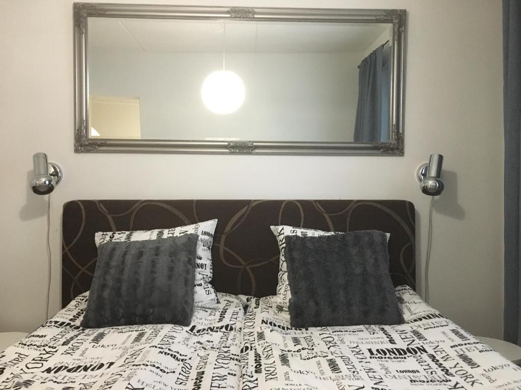 1 dormitorio con 1 cama con espejo grande en StarHomes Oulu, double en Oulu