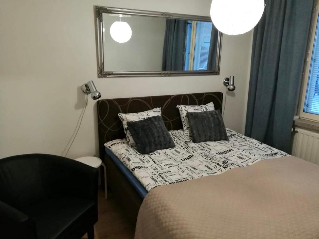 a bedroom with a bed with a mirror and a chair at StarHomes Oulu, double in Oulu