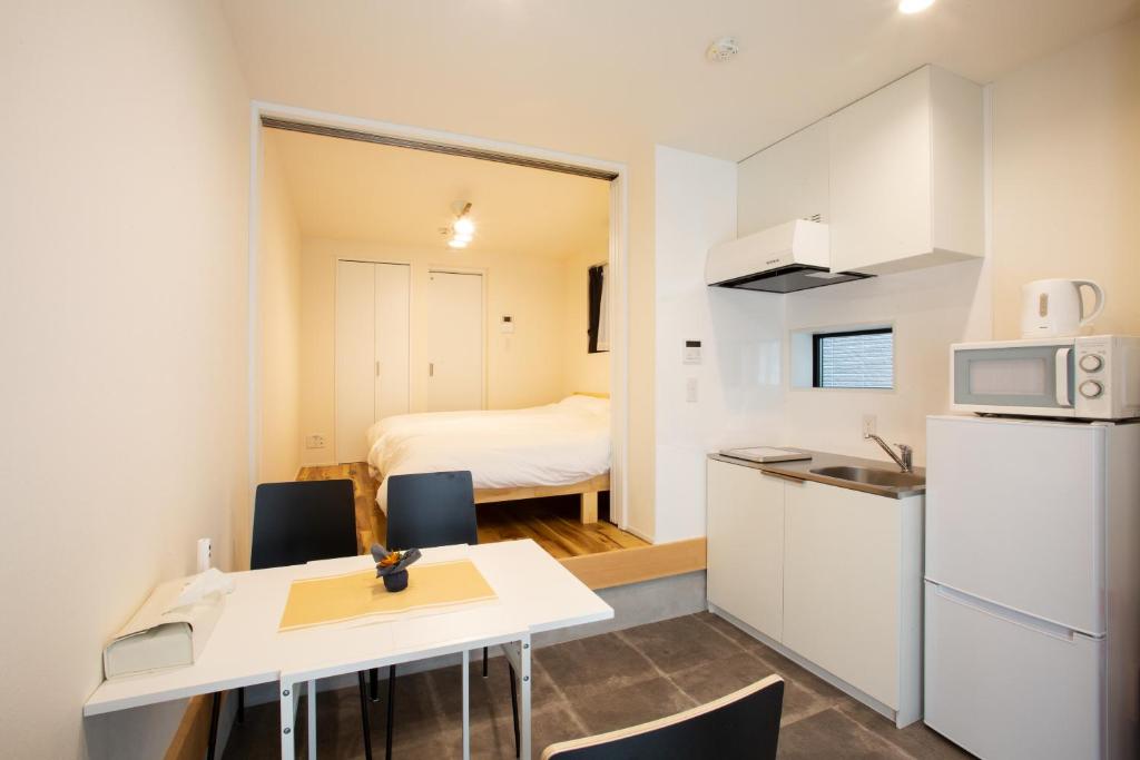 een klein appartement met een keuken en een slaapkamer bij スポルト東京 in Tokyo