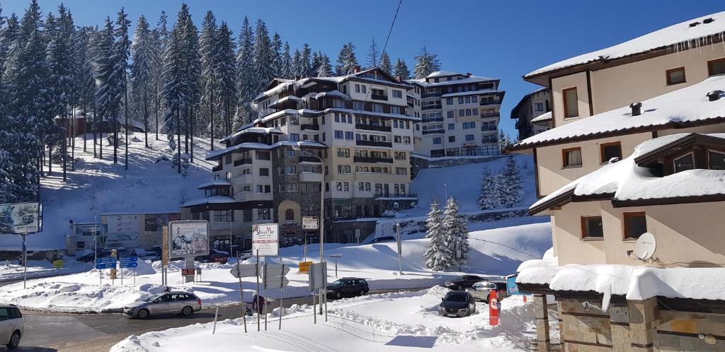 um grupo de edifícios numa montanha coberta de neve em Апартамент Pamporovo Palace em Pamporovo