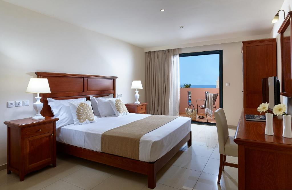 a hotel room with a bed and a balcony at Vasia Resort & Spa in Sisi