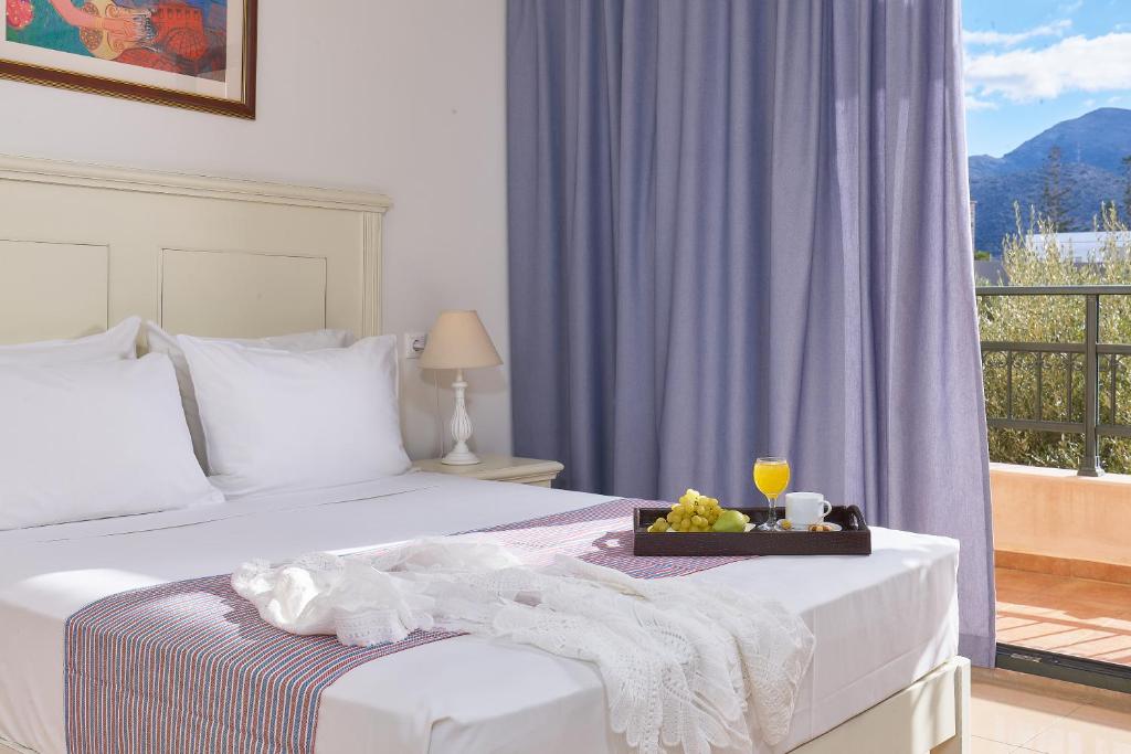 a hotel room with a bed with a tray of food at Vasia Resort & Spa in Sisi