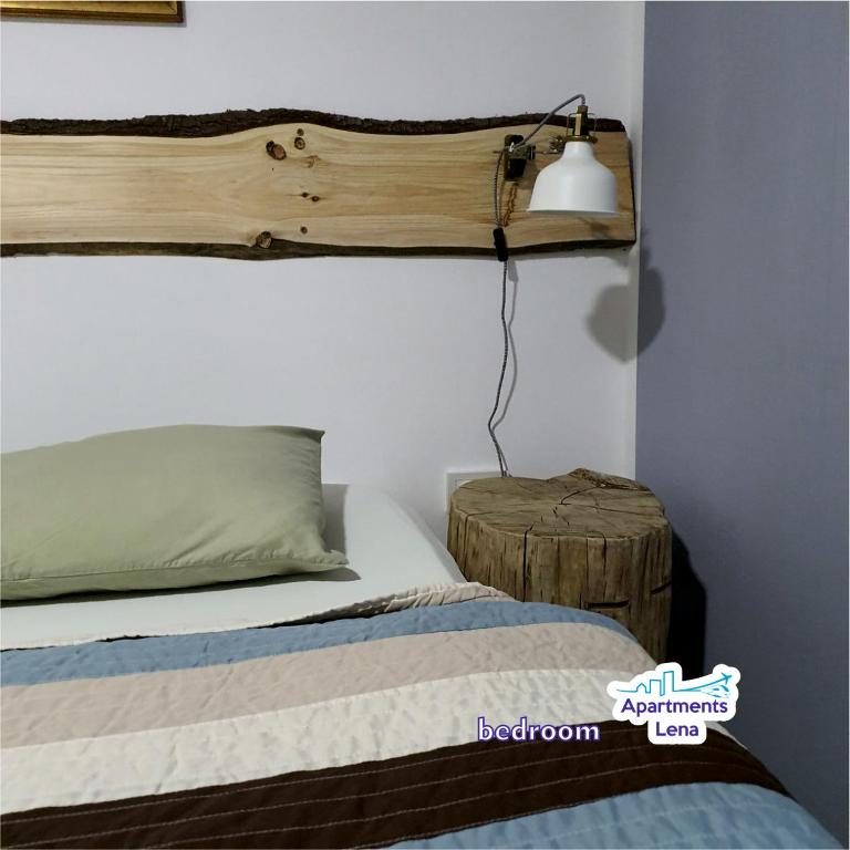 a bedroom with a bed with a wooden shelf above it at Apartment Lena Centar - best value, best choice! in Osijek