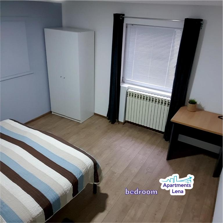 a bedroom with a bed and a desk and a window at Apartment Lena Centar - best value, best choice! in Osijek
