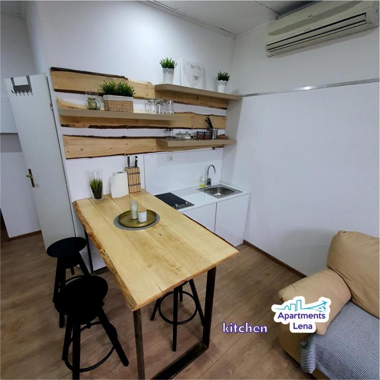 a small kitchen with a wooden table in a room at Apartment Lena Centar - best value, best choice! in Osijek