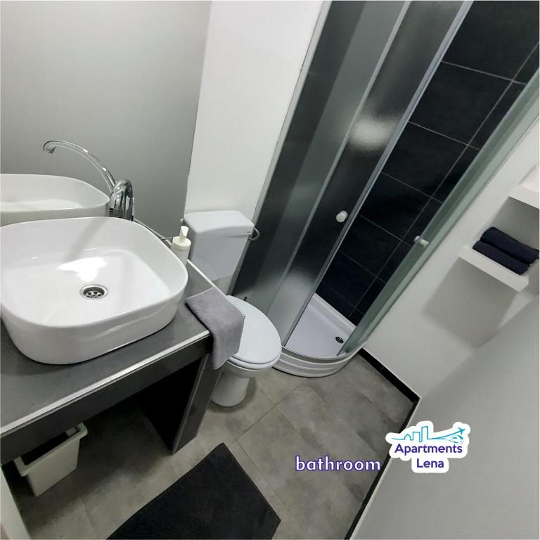 a bathroom with a white sink and a toilet at Apartment Lena Centar - best value, best choice! in Osijek