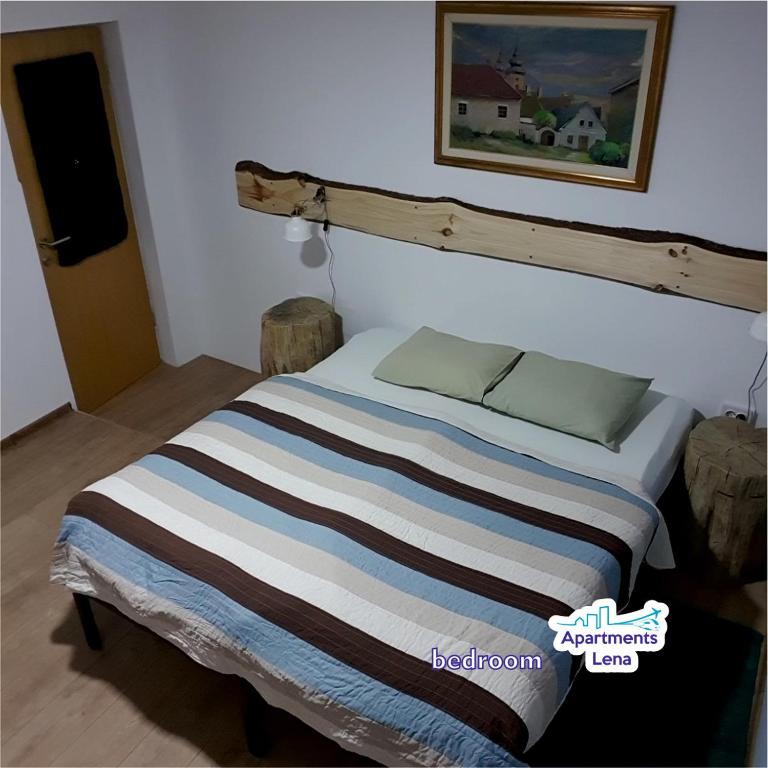 a bedroom with a bed with a striped blanket at Apartment Lena Centar - best value, best choice! in Osijek