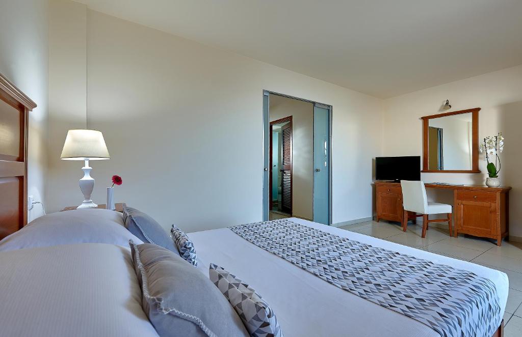 a bedroom with a bed and a desk and a table at Vasia Resort & Spa in Sisi