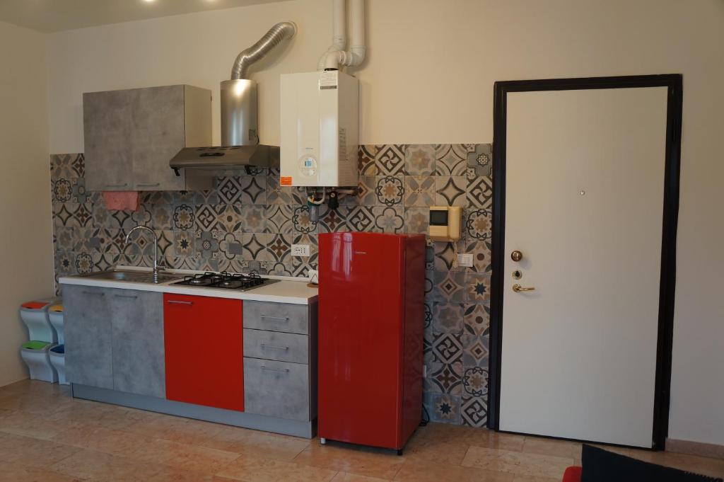 uma cozinha com armários vermelhos e um frigorífico vermelho em A casa dalla Fra 2 em Castelfranco Emilia