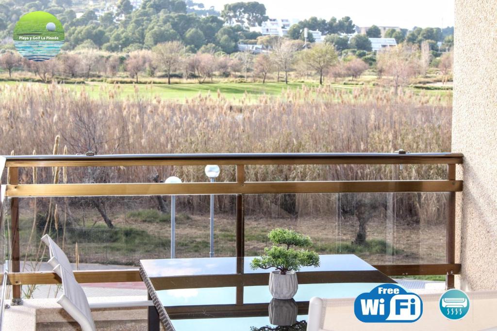 a balcony with a table and chairs and a view of a field at Playa y golf La Pineda in La Pineda