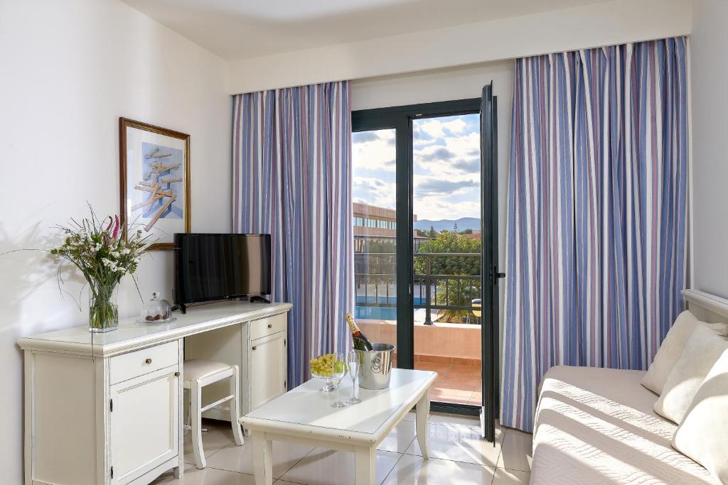 a living room with a couch and a television in a room at Vasia Resort & Spa in Sisi