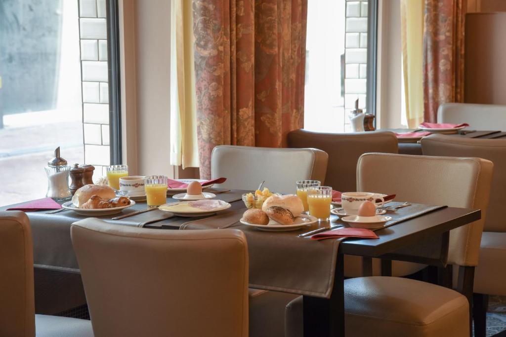 een eetkamer met tafels en stoelen met eten erop bij Hotel Du Commerce in Blankenberge