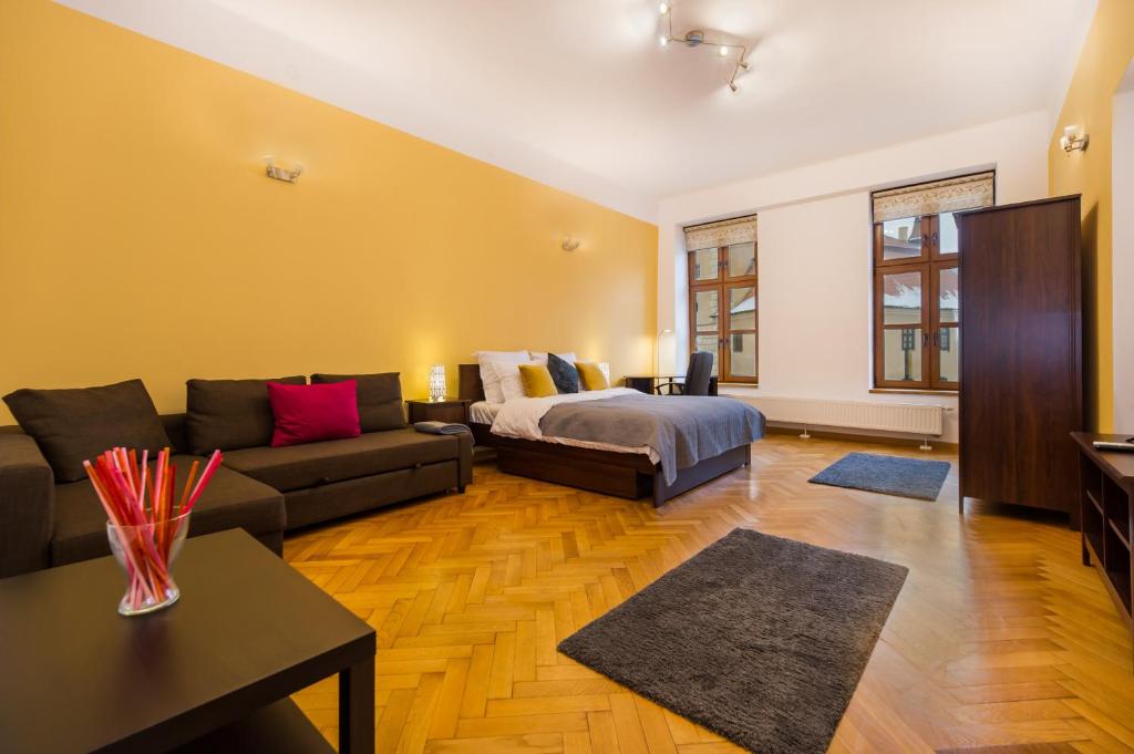 a living room with a couch and a bed at Council Square eState Apartment *Bull's Eye* in Braşov