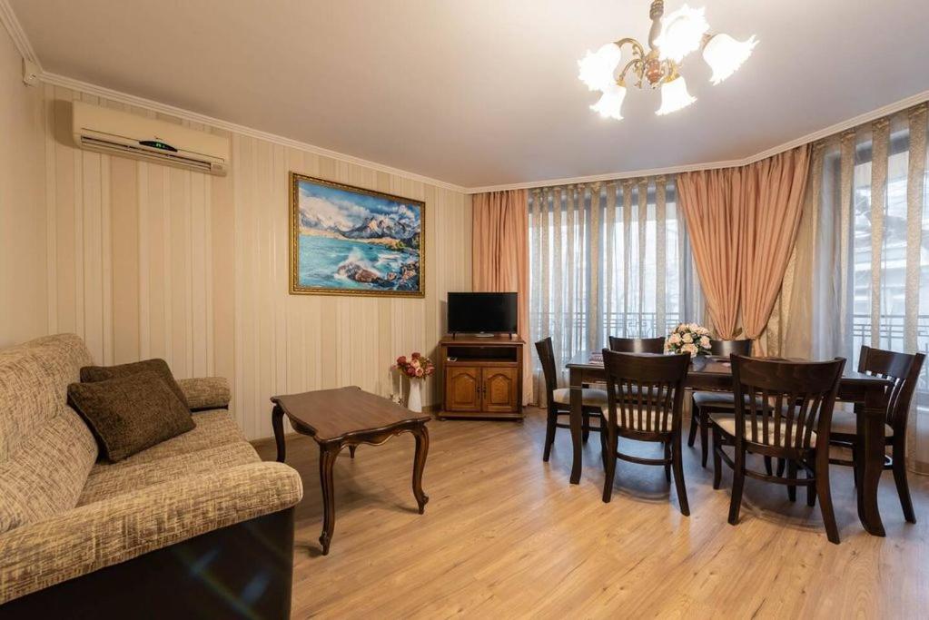 a living room with a couch and a table with chairs at Vazov Residence , two bedroom top centre apartment in Varna City