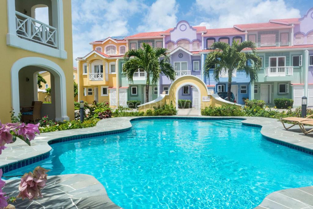 a pool in front of some colorful houses at The Harbour in Rodney Bay Village