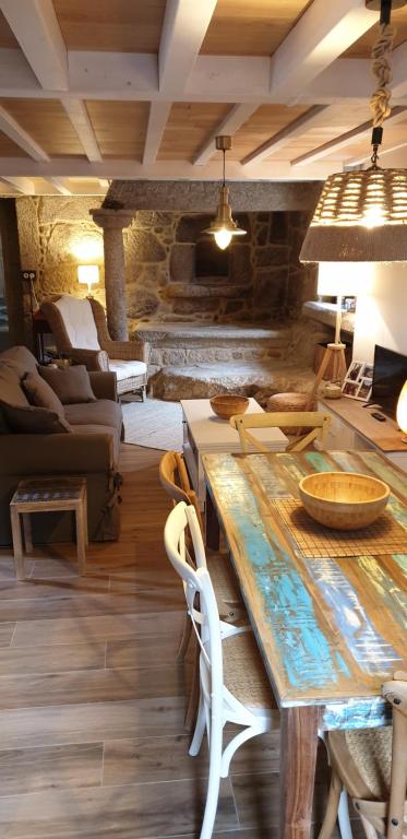 salon z drewnianym stołem i krzesłami w obiekcie OLardoMar w mieście San Mamede de Carnota