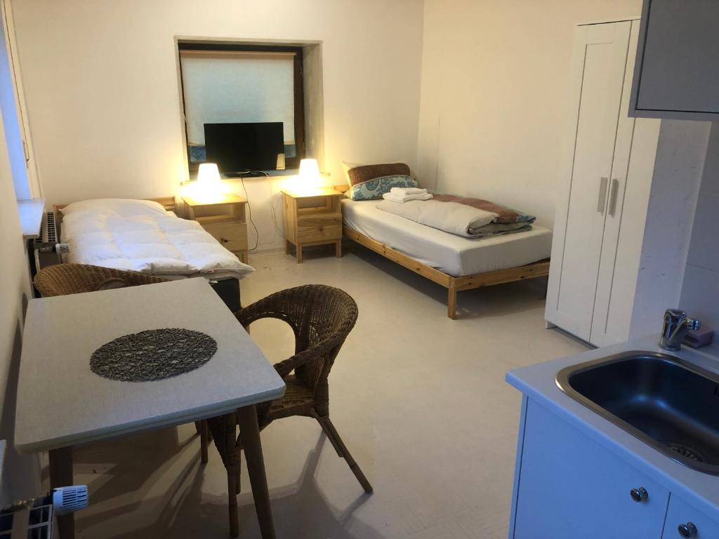 a kitchen with two beds and a table and a sink at Burgstudio in Alzenau in Unterfranken