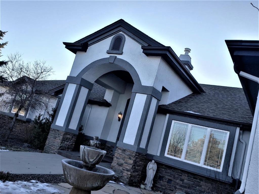 uma casa com uma arcada na frente dela em Peak Valley Manor, a Modern Farmhouse em Colorado Springs