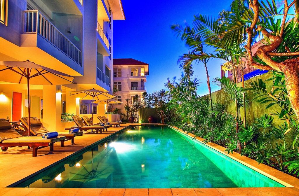 a swimming pool in front of a building at Sunset Residence and Condotel in Legian