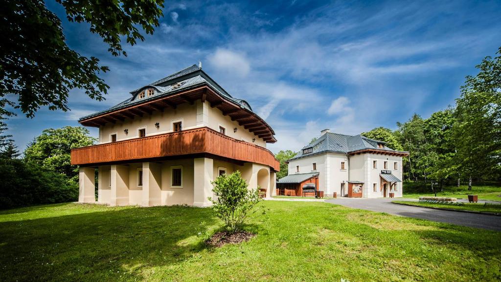 a building with a roof on top of a green field at Hotel Kristin Hrádek in Děčín