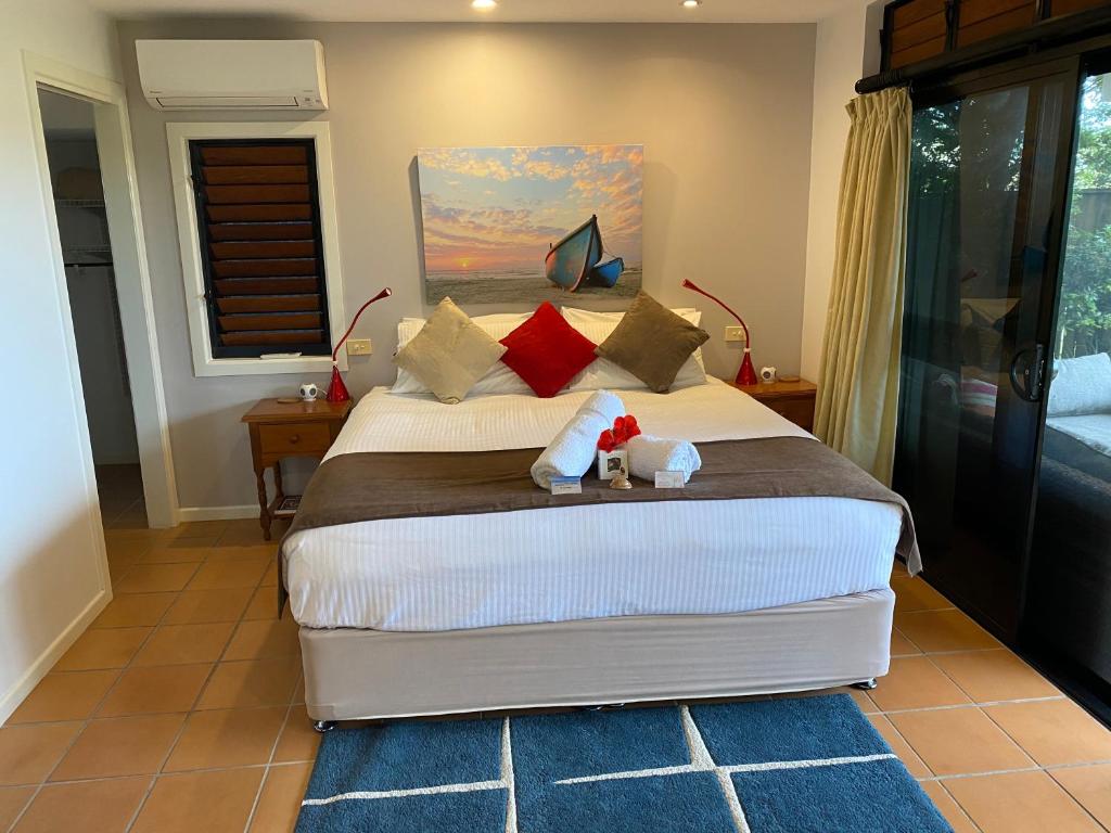 ein Schlafzimmer mit einem Bett mit zwei ausgestopften Tieren darauf in der Unterkunft The Boathouse in Yamba