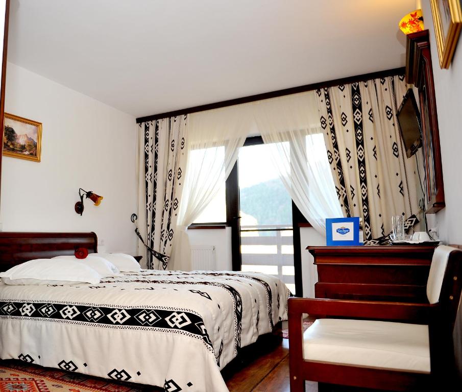 a bedroom with a bed and a window at Pensiunea Casa Doamnei Voronet in Gura Humorului