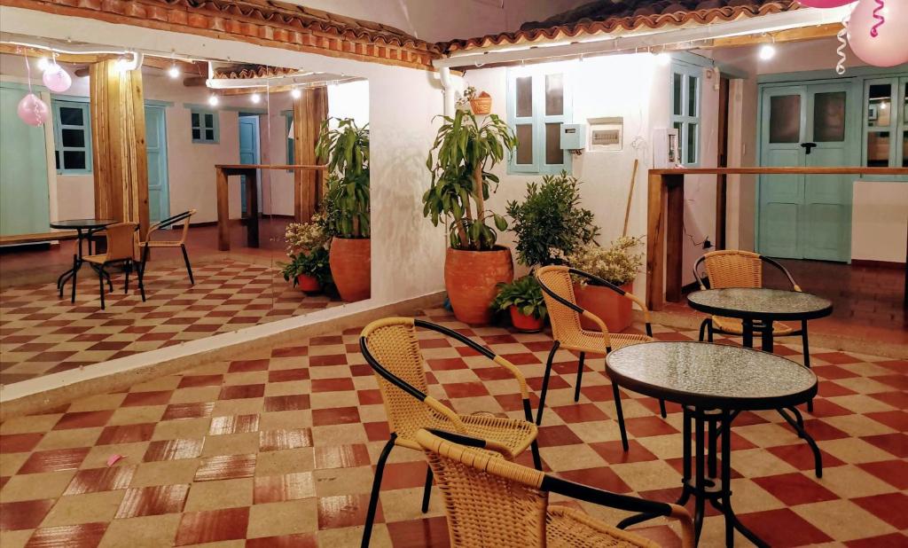 restauracja ze stołami i krzesłami w pokoju w obiekcie Popichi Hostel w mieście Villa de Leyva