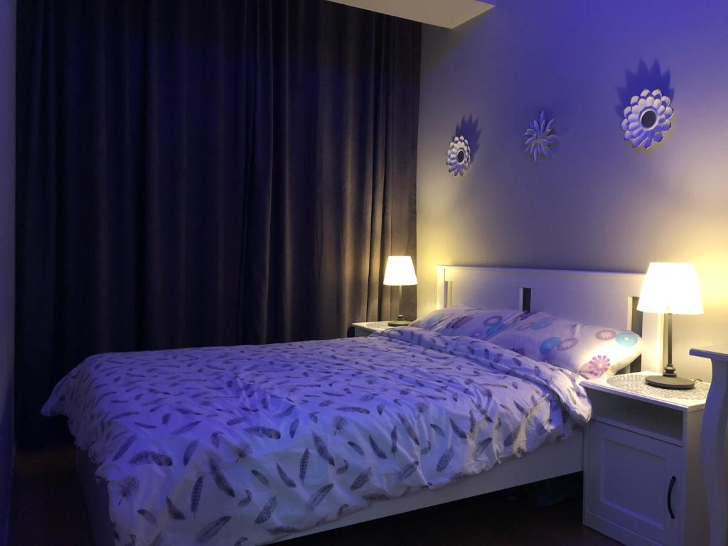 um quarto com uma cama com lençóis roxos e 2 candeeiros em Koza Apartment, next to Akbati Shopping Mall and Tennis court Soul Entertainment em Istambul