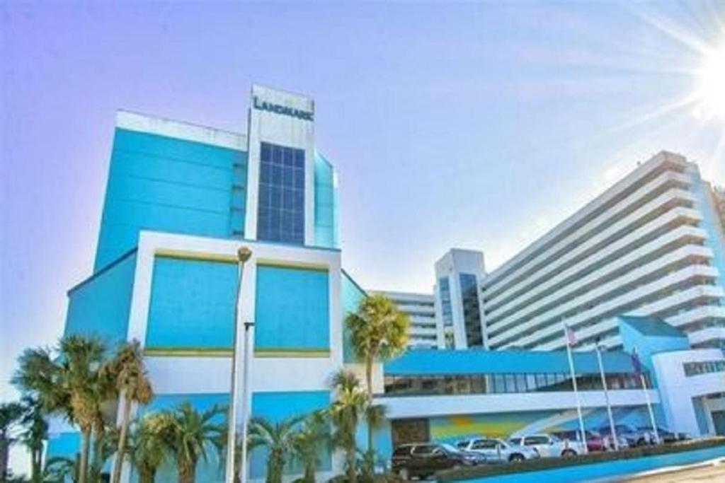 a blue building with palm trees in front of it at Lee's Myrtle Beach Condo in Myrtle Beach