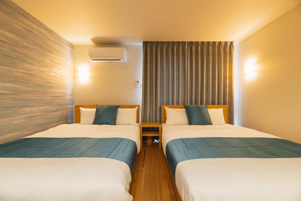 Postel nebo postele na pokoji v ubytování GRAND BASE Nagasaki City