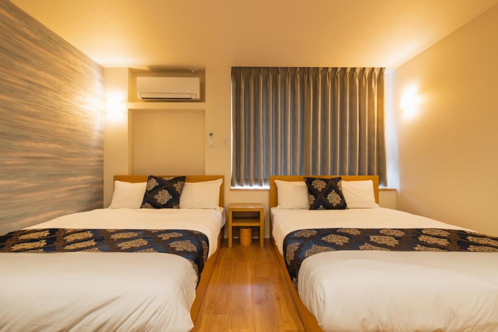 Postel nebo postele na pokoji v ubytování GRAND BASE Nagasaki City