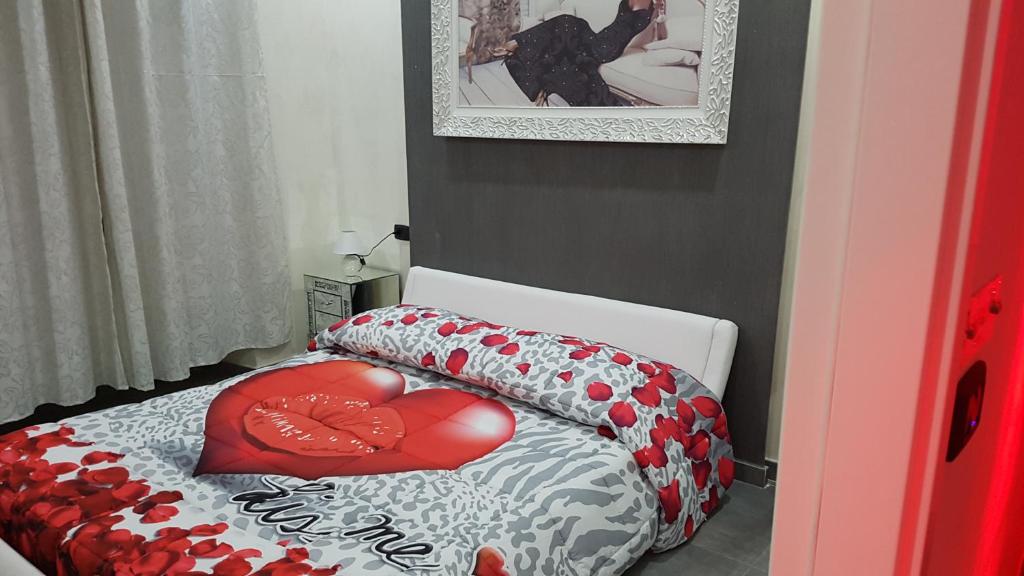 Un dormitorio con una cama con dos almohadas rojas. en hause luisa, en Nápoles