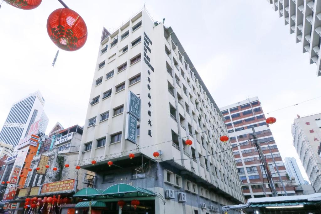 un edificio alto y blanco en medio de una ciudad en Nan Yeang Hotel Petaling Street, en Kuala Lumpur