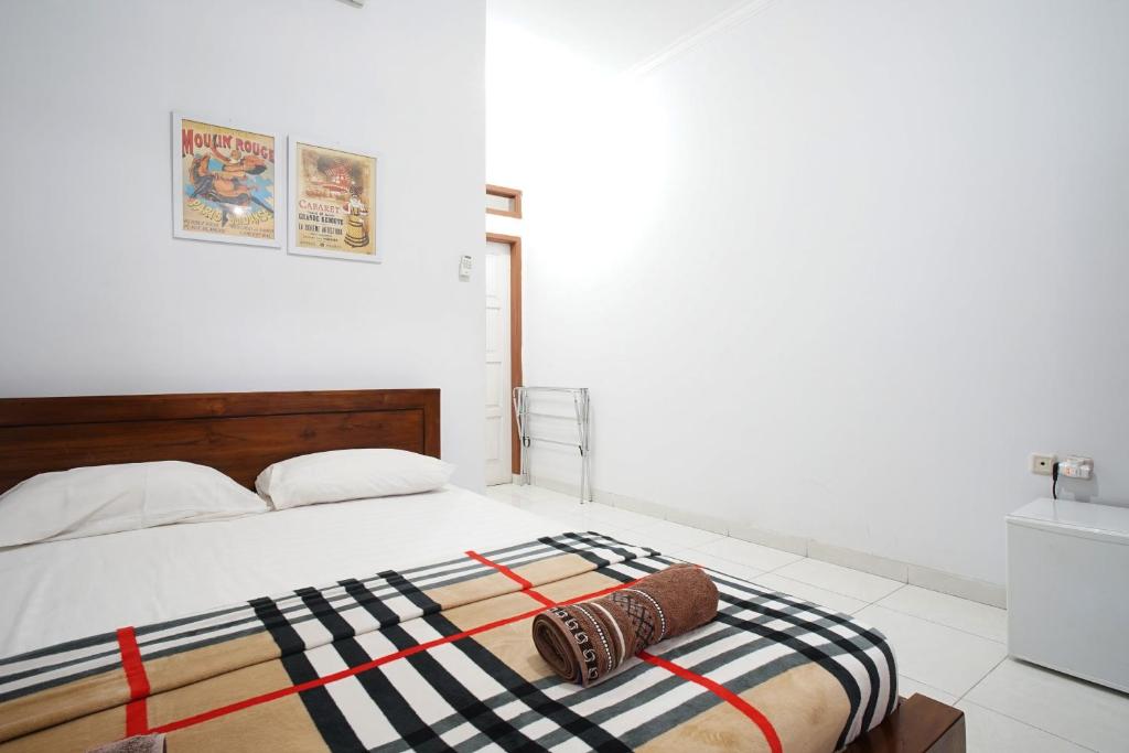 a bedroom with a bed with a striped blanket on it at Zenrra House in Bandung