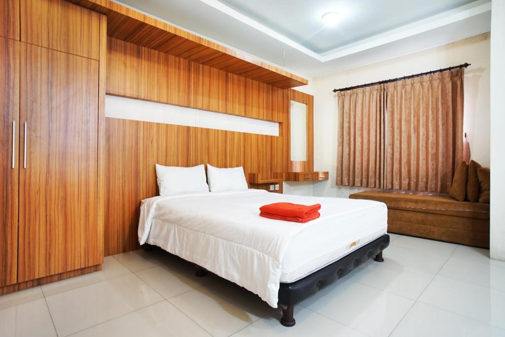 a bedroom with a large bed with a wooden wall at Kamarku Apartment in Cimindi-hilir