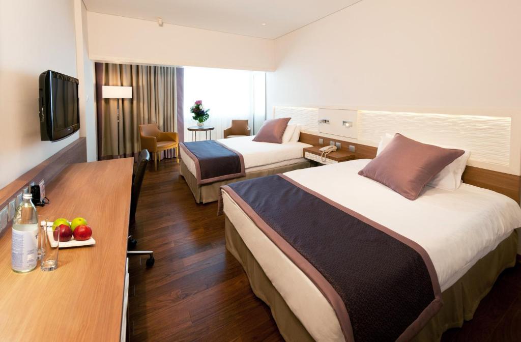 a hotel room with two beds and a table at Crowne Plaza Limassol by IHG in Limassol