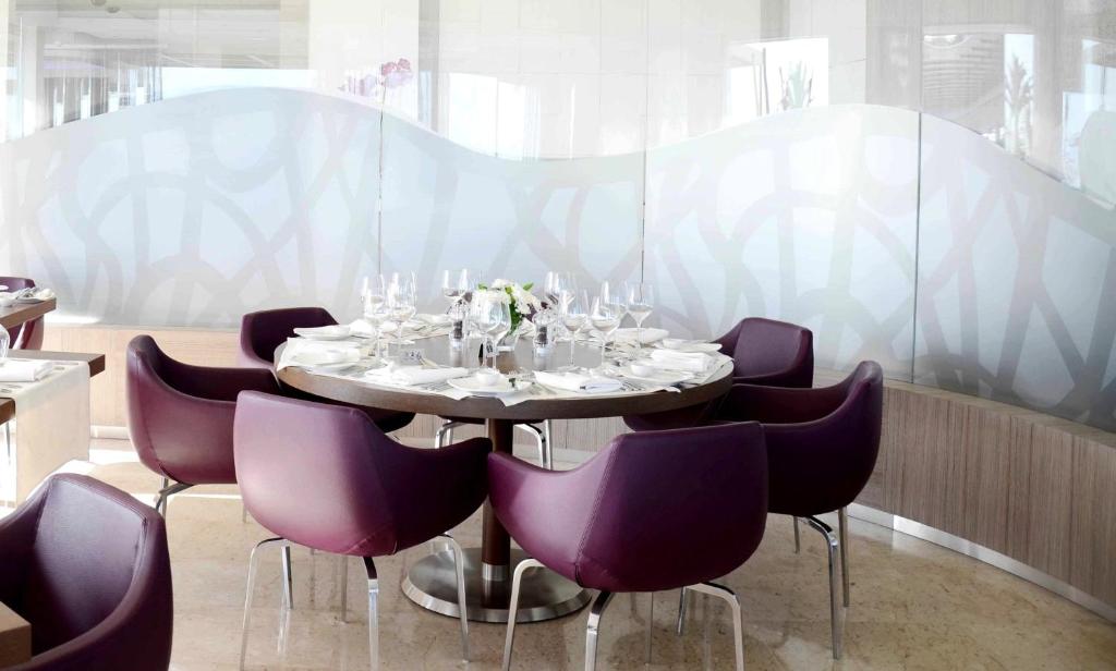 a dining room with a table and purple chairs at Crowne Plaza Limassol by IHG in Limassol