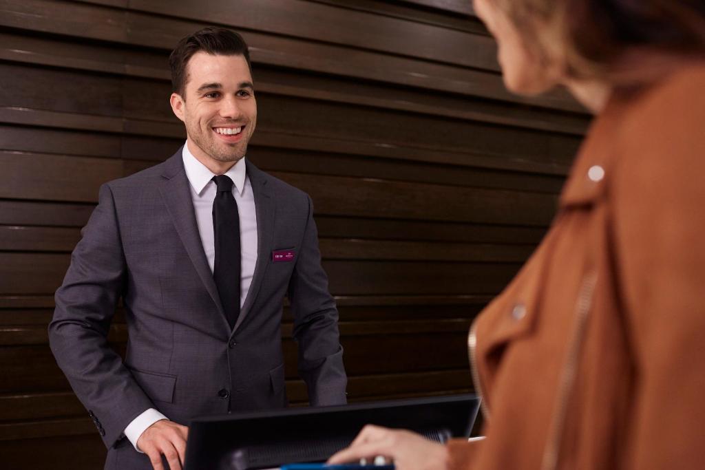a man in a suit and tie standing next to a woman at Crowne Plaza Limassol by IHG in Limassol