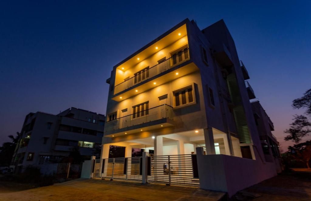 a tall building with lights on it at night at Orchid Elite Service apartments in Mysore