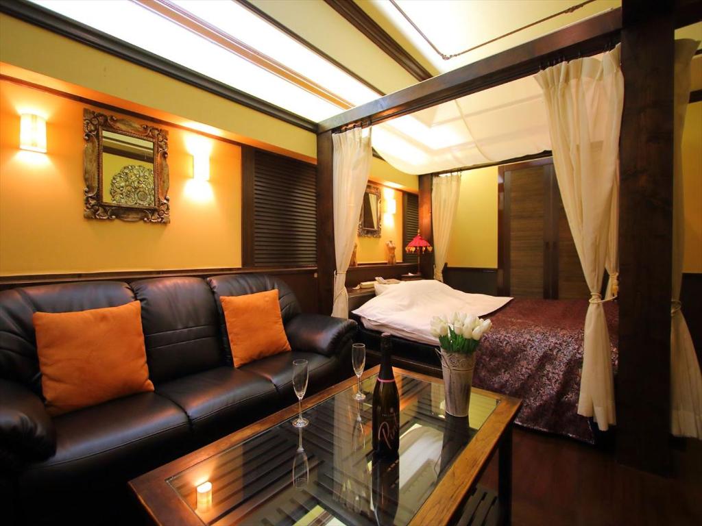 Hotel GIG (Adult Only) في كاواغويه: غرفة معيشة مع أريكة وسرير